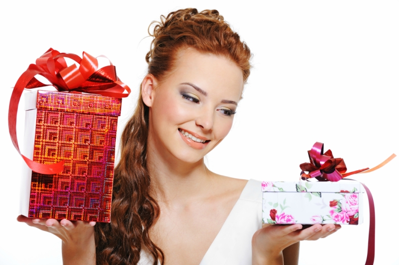 Happy smiling girl choosing between two gifts